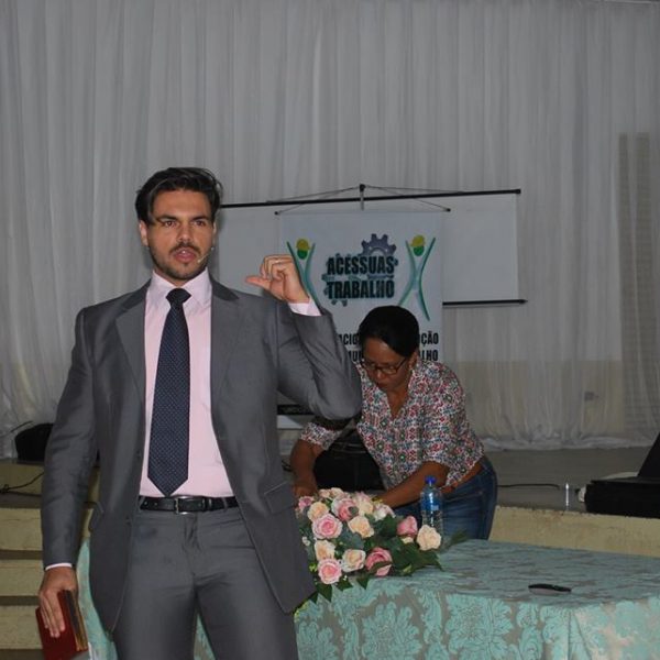 palestrante janderson santos segurando livro e falando