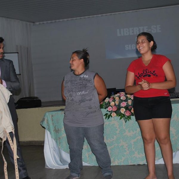 tres pessoas e um palestrante mágico segurando camisa de força