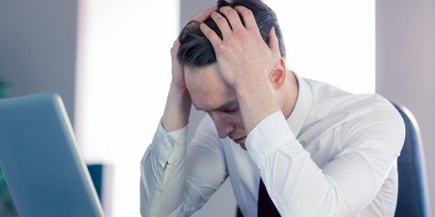 empresario-preocupado-com-a-cabeca-nas-maos_13339-236609