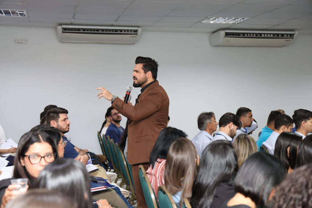 Palestrante de vendas em pé realizando palestra para vendedores