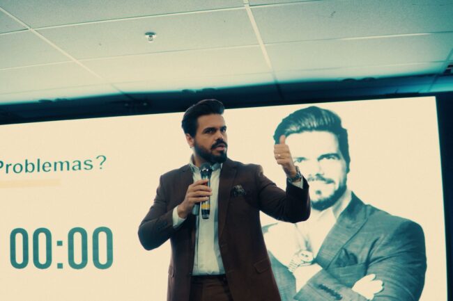 Janderson Santos, o Mago das Vendas, palestrante de vendas em ação no palco durante palestra sobre resultados comerciais
