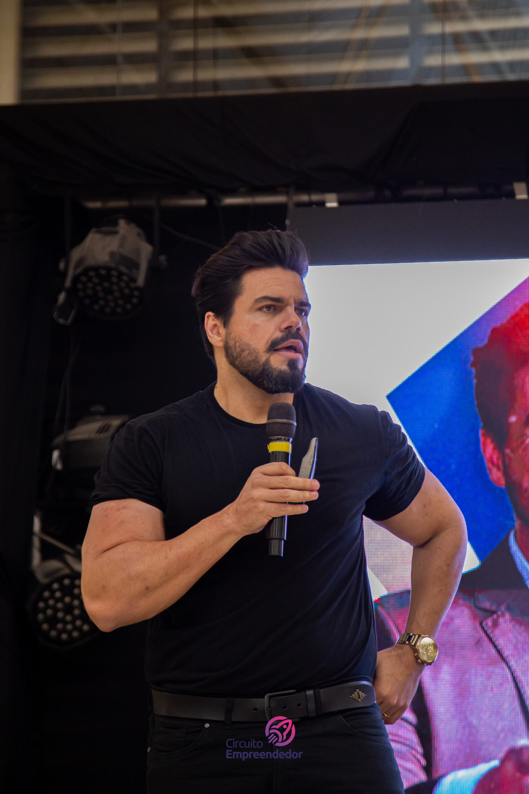 Janderson Santos, palestrante de vendas, com microfone em evento para vendedores — treinamento de vendas para empresas de Salvador
